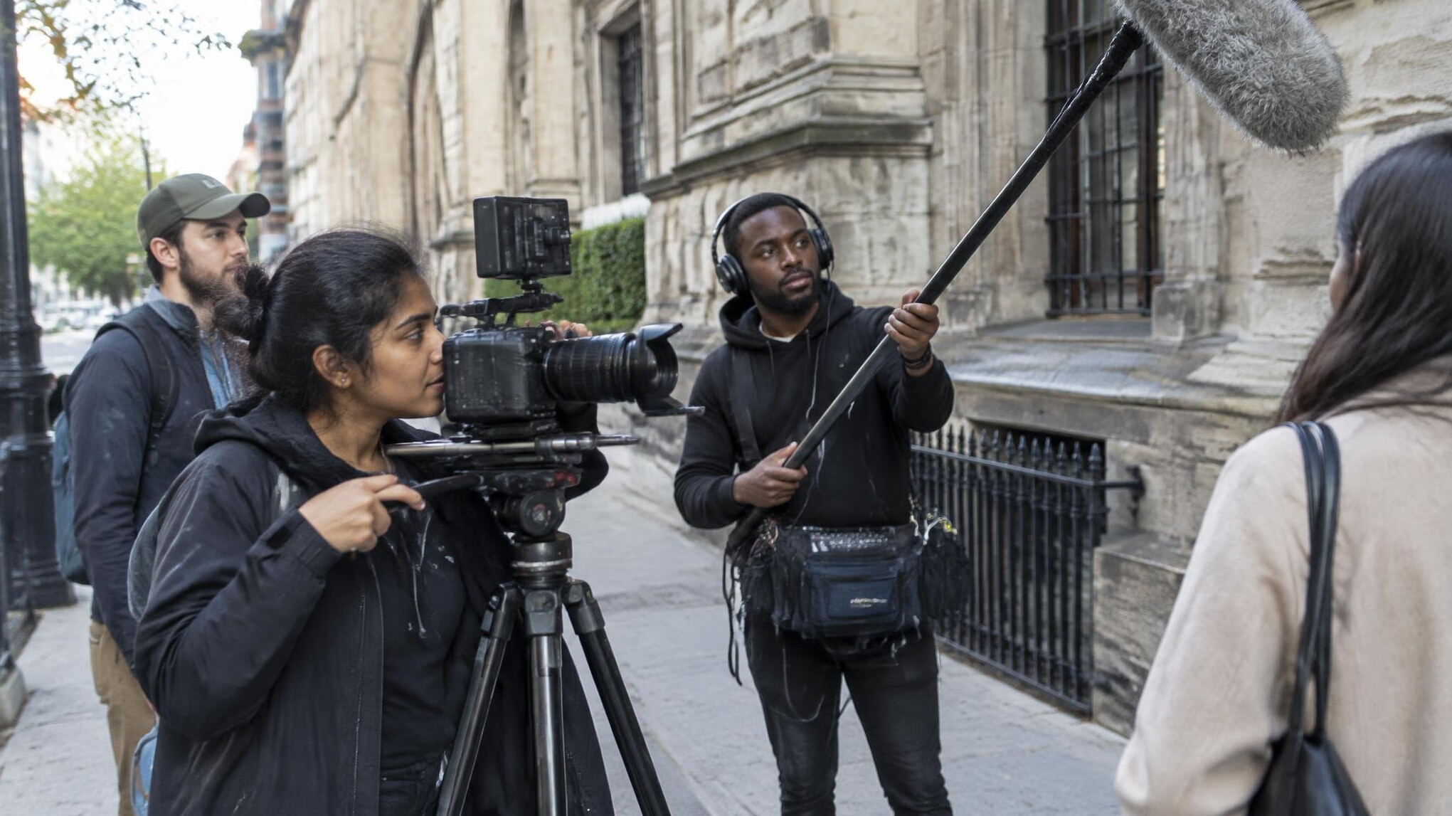 Documentary film crew filming on a city sidewalk